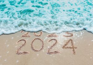 ocean and sand with Happy New Year 2024 from North Myrtle Beach Fishing Charters