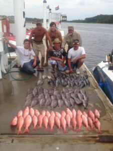 Men on the dock with bottom fish on it from a deep sea fishing trip with North Myrtle Beach Fishing Charters