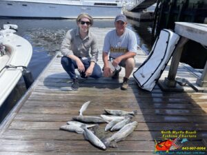 two men on the dock nailing down in front of speckled sea trout on a inshore fishing charters in March with North Myrtle Beach Fishing Charters