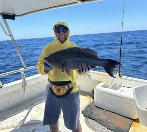 man holding a scamp grouper on the Long Way boat on a deep sea fishing charter in Myrtle Beach