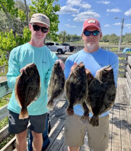 a son and father holding a flounder on a north Myrtle Beach fishing charter