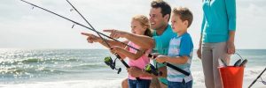 Family fishing at Myrtle Beach with ocean backdrop and fishing gear
