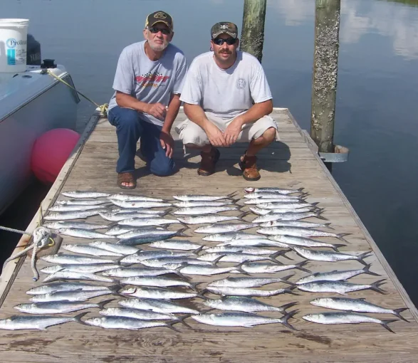 Two men with Spanish mackerel on the dock from a nearshore fishing charter in North Myrtle Beach