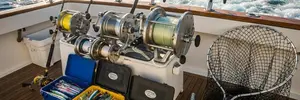 Variety of deep sea fishing gear on a boat deck with ocean backdrop