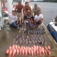 fish laying on the dock with fishermen standing behind them on a deep sea fishing myrtle beach charters